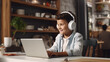 © stv - E-learning, child at home with headphones, laptop and homework for online class. A boy studies in a virtual school at home in the kitchen.