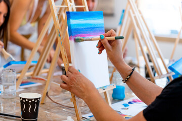 Painting Workshop. Closeup of a middle aged woman's hands painting