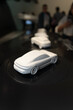 A prototype car. Car model. A miniature model of a Porsche car. White car models are displayed as exhibits that people look at.