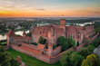 The Castle of the Teutonic Order in Malbork by the Nogat river at sunset. Poland
