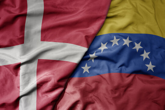 big waving national colorful flag of denmark and national flag of venezuela .