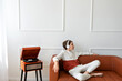 © Viktoriia - Teenager boy wearing earphones sitting on sofa near wooden retro turntable, chilling and listening vinyl record music. Lifestyle, minimalist home interior, empty white wall background