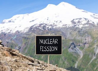 Wall Mural - Nuclear fission symbol. Concept words Nuclear fission on beautiful black chalk blackboard. Chalkboard. Beautiful mountain Elbrus background. Business science nuclear fission concept. Copy space.
