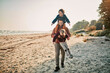 © Marko Geber - Happy young father taking his kids for a walk on a sandy beach during winter