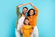 © Prostock-studio - Family insurance concept. Happy european parents making symbolic roof of hands above little daughter, blue background