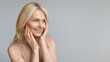 © Prostock-studio - Beautiful mature woman looking aside at copy space and touching cheeks, enjoying skincare treatments, panorama