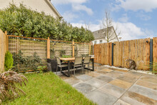 Backyard With Table And Chairs By Fence