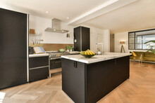 Interior Of Stylish Kitchen With Black Cabinets And Island