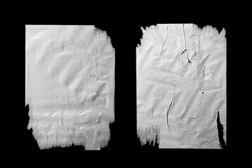 two sheets of white torn paper with folds isolated on a black background.