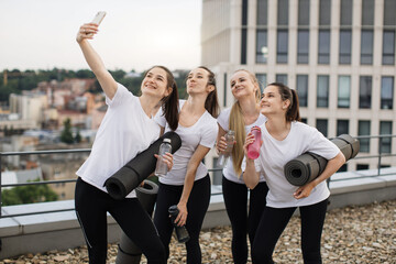 Wall Mural - Yoginis taking self-photo on mobile after outdoor exercises