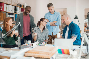 Multigenerational diverse group of architects working together on a project in a startup company office