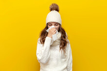 Sick Girl In Warm Soft Winter Clothes With Runny Nose In Napkin On Yellow Isolated Background, Cold Woman