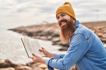 Poster - Young redhead man smiling confident reading book at seaside