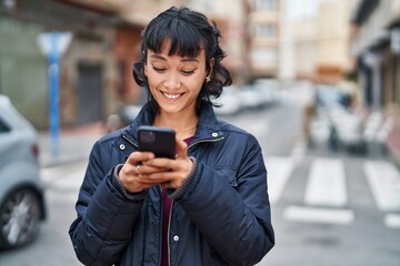 Poster - Young beautiful hispanic woman smiling confident using smartphone at street