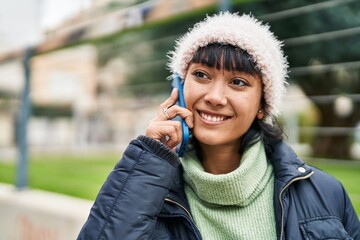 Canvas Print - Young beautiful hispanic woman smiling confident talking on smartphone at street