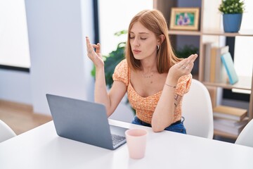 Wall Mural - Young redhead woman doing yoga exercise using laptop at home