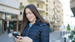 © Krakenimages.com - Young caucasian woman smiling confident using smartphone at street