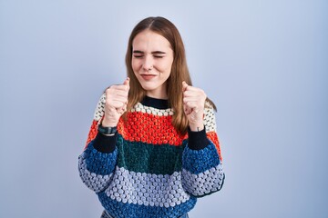 Poster - Young hispanic girl standing over blue background excited for success with arms raised and eyes closed celebrating victory smiling. winner concept.