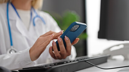 Poster - Young blonde woman doctor using smartphone working at clinic