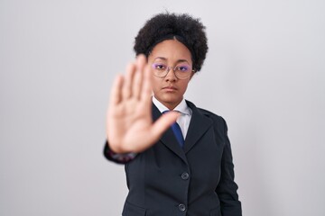 Poster - Beautiful african woman with curly hair wearing business jacket and glasses doing stop sing with palm of the hand. warning expression with negative and serious gesture on the face.