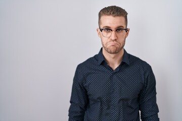 Wall Mural - Young caucasian man standing over isolated background depressed and worry for distress, crying angry and afraid. sad expression.