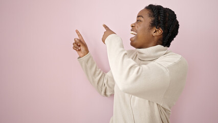 Canvas Print - African american woman smiling pointing to the side over isolated pink background