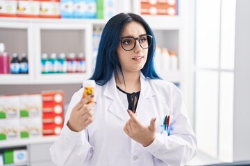 Sticker - Young caucasian woman pharmacist holding pills bottle speaking at pharmacy