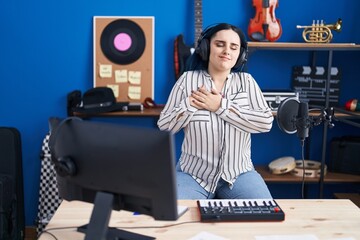 Sticker - Young modern girl with blue hair at music studio wearing headphones smiling with hands on chest, eyes closed with grateful gesture on face. health concept.