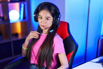 Poster - Young chinese woman streamer smiling confident sitting on bed at gaming room