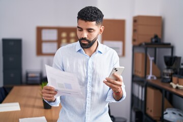 Poster - Young arab man business worker using smartphone reading document at office