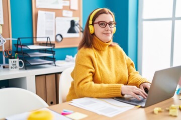 Young beautiful plus size woman business worker using laptop and headphones working at office