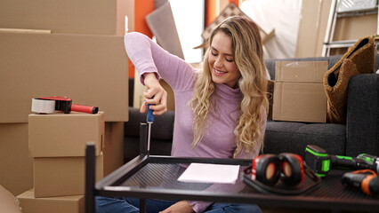 Sticker - Young blonde woman repairing table using screwdriver at new home