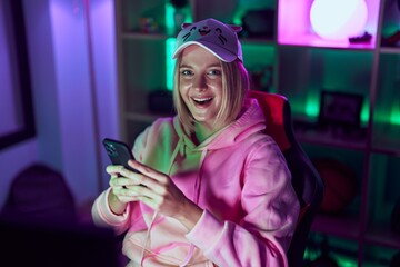 Poster - Young blonde woman streamer using smartphone at gaming room