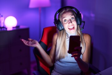 Sticker - Young caucasian woman playing video games with smartphone celebrating achievement with happy smile and winner expression with raised hand