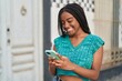 © Krakenimages.com - African american woman smiling confident using smartphone at street