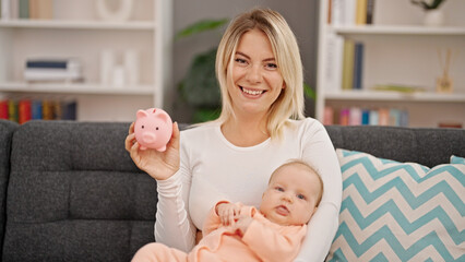 Poster - Mother and daughter hugging each other holding piggy bank at home