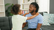 © Krakenimages.com - African american father and daughter smiling confident sitting on sofa together speaking at home