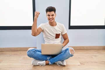 Sticker - Young hispanic man using laptop at home angry and mad raising fist frustrated and furious while shouting with anger. rage and aggressive concept.