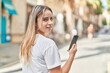 © Krakenimages.com - Young blonde woman smiling confident using smartphone at street