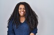 © Krakenimages.com - Plus size hispanic woman standing over white background with a happy and cool smile on face. lucky person.