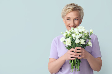 Poster - Mature woman with beautiful roses on light background