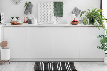 Wall Mural - Interior of modern kitchen with stylish rug, trash bin and white counters