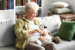 © Pixel-Shot - Senior woman with cute cat and knitting needles resting at home