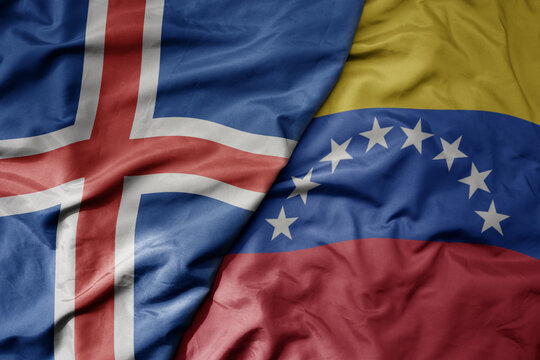 big waving national colorful flag of icelandic and national flag of venezuela .