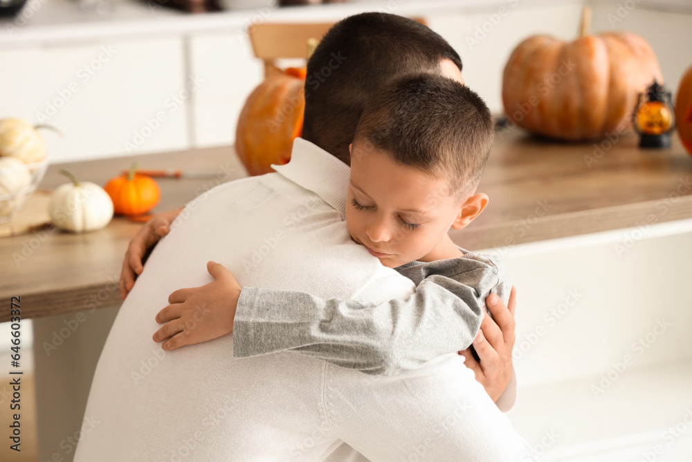 Little boy hugging his father in kitchen