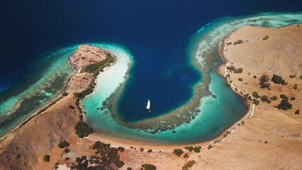 Poster - Boat anchored in the lagoon in the Komodo National Park during sunny calm day, Flores island, Indonesia. Aerial view of the tropical islands and lagoons with turquoise water