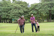 © jittawit.21 - Senior couple with granddaughter on a walk outside in nature. Seniors with granddaughter, summer day. People walking on grass.