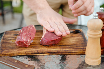 Rubbing olive oil over raw strip steak