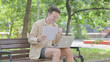 © stockbakers - Modern Young Man Celebrating Contract while Working on Laptop Outdoor