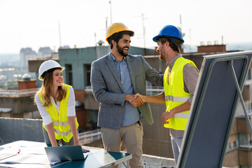 Wall Mural - Diverse team of specialists with computer on construction site. Building project with engineers